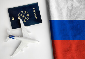 Flag of Russia with passport and toy airplane. Flight travel concept.
