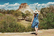 A young woman tourist stands in front of the Pyramid of the Magician in an ancient Mayan complex Uxmal in Mexico. The girl enjoys the view of the Mayan pyramid. Travel concept
