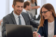 © ASDF - man and woman sitting at table in co-working office