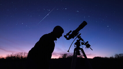 Wall Mural - silhouette of a man, telescope and countryside under evening skies.