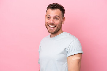 Wall Mural - Young Brazilian man wearing a band-aids isolated on pink background with surprise and shocked facial expression