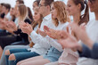 © ASDF - close up. young people sitting in a row applaud.