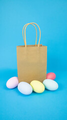 Easter, paper bag, gift and eggs are plain, multi-colored on a blue background. Holiday concept, gifts, sale. High quality photo