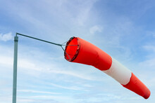 Close Up Of A Windsock Against Blue Sky With Clouds