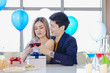 © Bangkok Click Studio - Millennial young lover couple Asian husband in formal suit and beautiful wife smiling holding tall glasses wine toasting cheers together in happy new year party at decorated beverage and food table