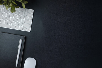 top view working desk with keyboard mouse and notebook on black table background