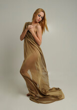  Full Length Portrait Of Pretty Female Model Wearing  Grecian Goddess  Toga Gown, Posing With Elegant Gestural Movements On A Studio Background.