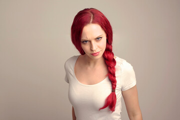 Poster - close up portrait of pretty female model with red hair in a braid, expressing emotion over the top facial expression on a studio background.