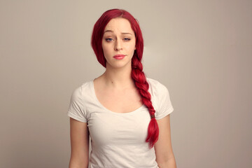 Sticker - close up portrait of pretty female model with red hair in a braid, expressing emotion over the top facial expression on a studio background.