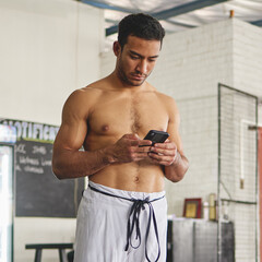 Poster - Just finished training. Cropped shot of a handsome young man standing using his phone while standing shirtless in his jiu jitsu pants in the gym.