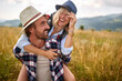 © luckybusiness - A young happy couple in love is playing while walking a meadow. Hiking, nature, relationship, together