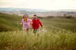 © luckybusiness - A young couple holding hands and running through the meadow. Relationship, together, love