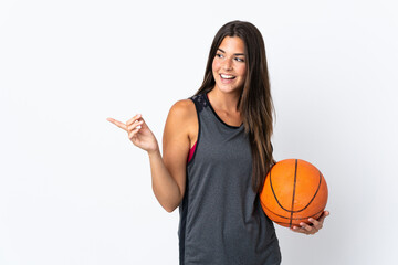 Young brazilian woman playing basketball isolated on white background pointing finger to the side and presenting a product