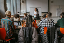 Female Professor Teaching University Students In Classroom