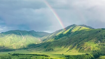 Wall Mural - Aerial footage of green mountains and beautiful rainbow nature scenery in Xinjiang, China.