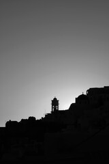 Amazing golden sunset and silhouette view of  churches and the village of Imerovigli in Santoriniin black and white 