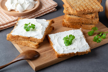 Bread with cream cheese on grey table. Whole grain bread with seeds