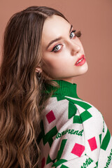 Portrait of a young beautiful teenage girl on a beige isolated background