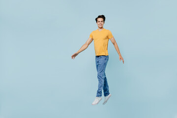 full body smiling happy cheerful fun satisfied young man 20s wear yellow t-shirt jump high look came