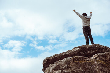 Succesfull man full of joy on the peack of the mountain