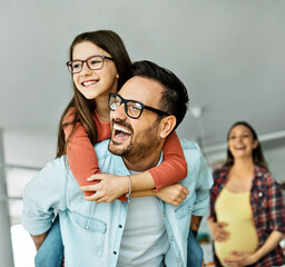 child daughter family happy father piggyback playing fun together girl cheerful smiling home indoor mother pregnant pregnancy maternity expecting baby belly