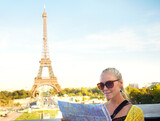 Fototapeta Paryż - This map is very accurate. A pretty young woman holding a map while sight seeing in the Paris.