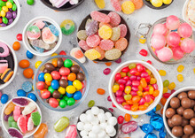 Pink Lollipop Candies In Jar With Various Milk Chocolate And Jelly Gums Candies On White Background With Liquorice Allsorts And Strawberry Bonbons