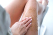 A woman applies scrub on her legs. Women use anti-cellulite cream. female body care. Cosmetology, massage, spa cosmetics.