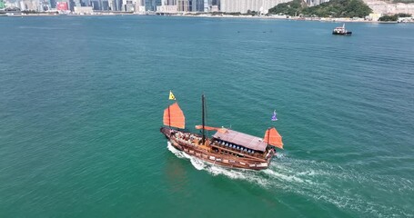 Fototapete - Hong Kong 12 December 2021: Red Sail Junk cross the harbor
