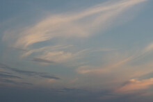 Skyscape Background Of Fine Wispy White Summer Clouds In A Pale Blue Sunset Sky