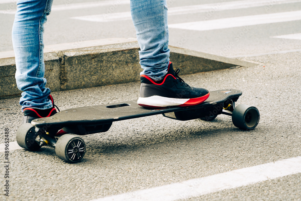 skateboard. skateboard foot detail. young man waiting at the traffic light to cross on his skateboard.