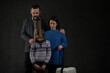 © Halfpoint - Refugee family with one child looking down on black background, Ukraine war concept.