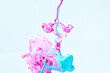 Paints splash curves in water on white. Acrylic paint drop background. Abstract pink and blue colors swirl texture