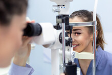 Female Doctor Ophthalmologist Is Checking The Eye Vision Of Attractive Young Woman In Modern Clinic. Doctor And Patient In Ophthalmology Clinic.