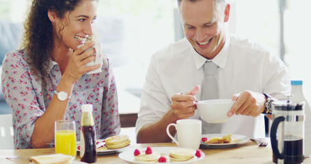 Wall Mural - Happiness happens at the breakfast table. Shot of a happy middle aged couple having breakfast together in the morning at home.