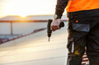 © dusanpetkovic1 - Cropped picture of a worker holding electrical screwdriver and preparing to work on solar panels.