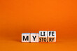 Story of my life symbol. Turned wooden cubes and changed concept words My story to My life. Beautiful orange table orange background. Business story of my life concept. Copy space.