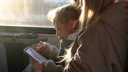 Wall Mural - Mom helps her daughter draw a picture while they are on the train