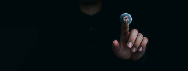 Blue fingerprint scan icon on virtual screen while finger scanning for security access with biometrics identification on dark. Cyber security, privacy data protection technology for business.