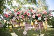 The wedding arch decorated with flowers stands in the luxurious area of the wedding ceremony.