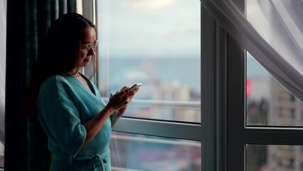 smartphone using at home, adult woman is scrolling screen of cell phone and viewing news