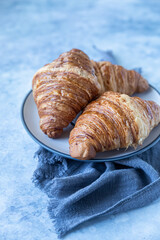 Wall Mural - Tasty crispy croissants, blue background. Bakery for breakfast.