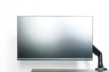Modern Matte Computer Monitor Or TV Set Is Mounted On A Small Table With A Metal Bracket. Off-center Side Holder. The Edge Of The Table. Free Space For An Inscription