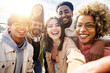 canvas print picture - United group of happy young friends having fun while taking a selfie with mobile phone outdoors - Diverse group of millennial people laughing together during vacation - Friendship and holidays concept
