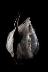 ballerina with a white dress and black top posing on black background