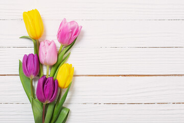 Wall Mural - bouquet of tulips on white wooden background