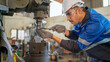 © bung - Engineer man checking the status of machine and used wrench to screw some part of equipment at CNC factory. Worker wearing safety glasses and helmet. Maintenance and repairing concept.