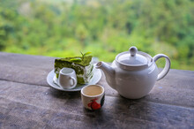 Tea Set, Cups And Teapot Of Green Tea On Wooden Board With Mountain And Forest Background
