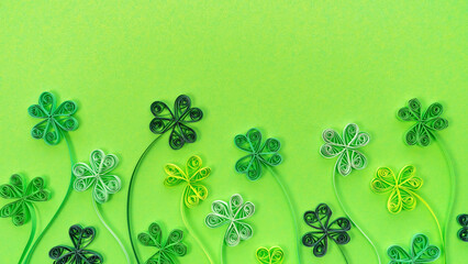 Wall Mural - Shamrock leaves in quilling technique on a green background with copy space. St. Patrick's day sale promotion banner. St. Patrick's Day background with clover and trefoil. Good luck concept banner.