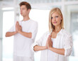 © D M/peopleimages.com - Serentiy. Shot of two young people doing yoga together.